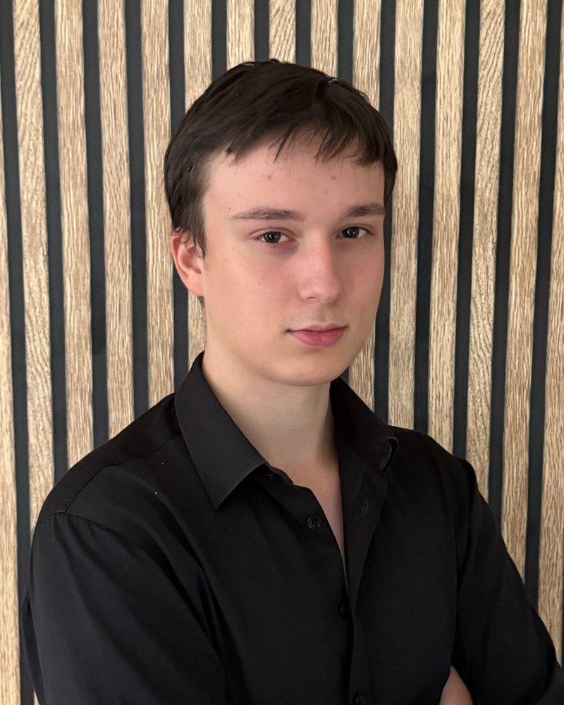 Leo Noculak, technical partner at SiteForNow, in a black shirt against a slatted wood wall