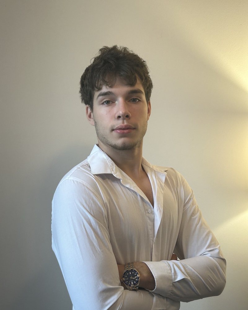 Mikołaj Maksymow, founder of SiteForNow, in a white shirt with arms crossed